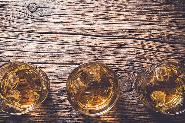 istock Glasses of whiskey on wooden table 526825650