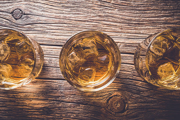 istock Glasses of whiskey on wooden table 526825736