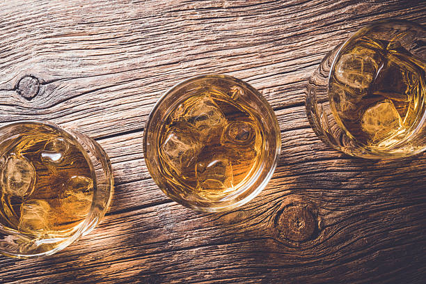 istock Glasses of whiskey on wooden table 526825824