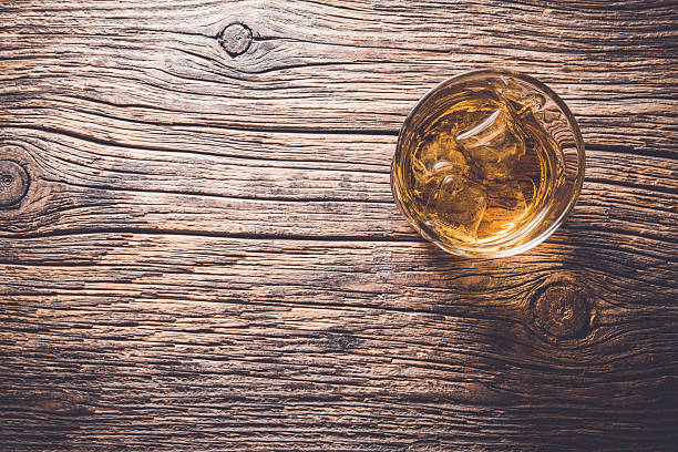Glass of whiskey on wooden table