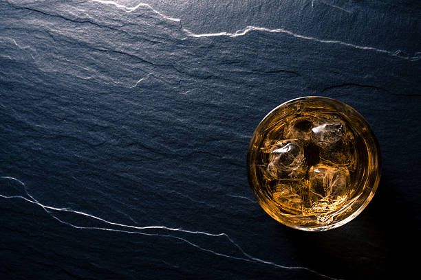 Glass of whiskey on dark table