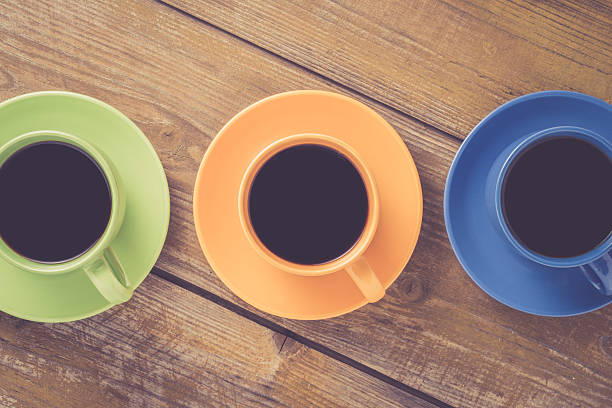 istock Coffee cups on yellow wooden table 526828588