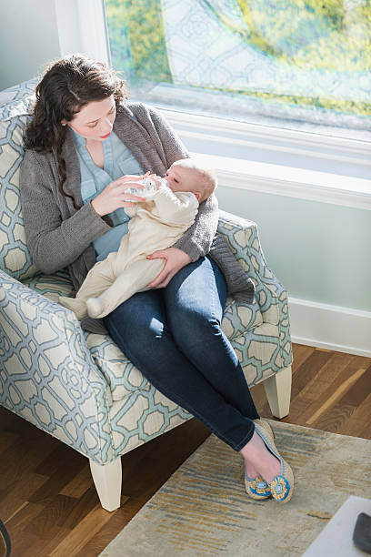 istock Mother feeding baby with bottle 526830252