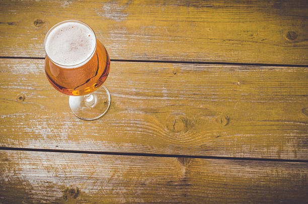 istock Beer glass on an old yellow wooden table 526831020