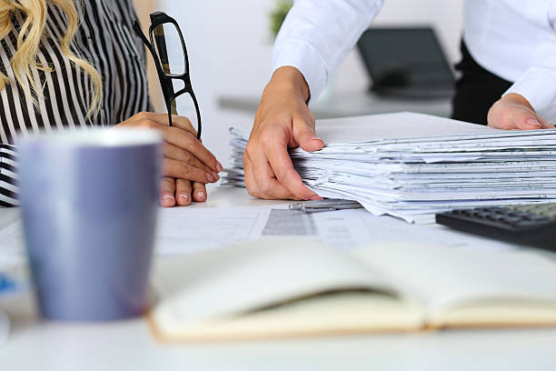 Hands of two women in office Hands of two women in office. Employee showing pack of documents to manager or boss giving extra work to executor. Overwork, overtime, deadline, paperwork, project approval, teamwork concept irs office stock pictures, royalty-free photos & images