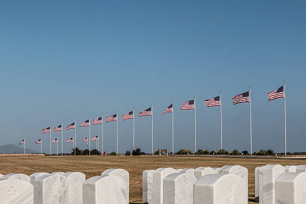 Rows of Tombstones and Flags at Miramar National Cemetery Row of tombstones and Avenue of Flags at Miramar National Cemetery in San Diego, California. national cemetery stock pictures, royalty-free photos & images