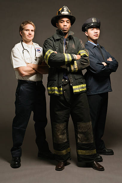 oficial de policía, técnico en urgencias médicas y fireman, sobre fondo negro, vertical - fire department heroes portrait occupation fotografías e imágenes de stock