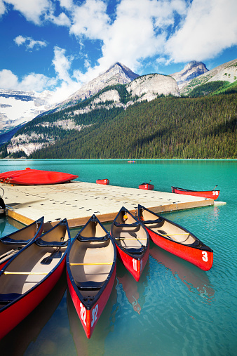 Canoe rental dock at Lake Louise in the Banff National Park of Canada, with its emerald water and mountain range of the Canadian Rockies.