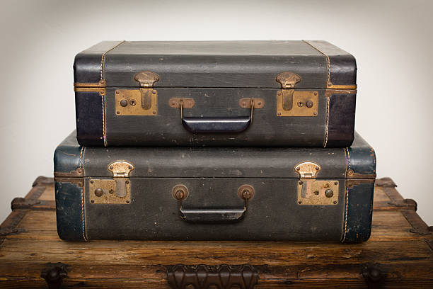 istock Two Old Matching Blue Suitcases Stacked on Wood Trunk 526838014