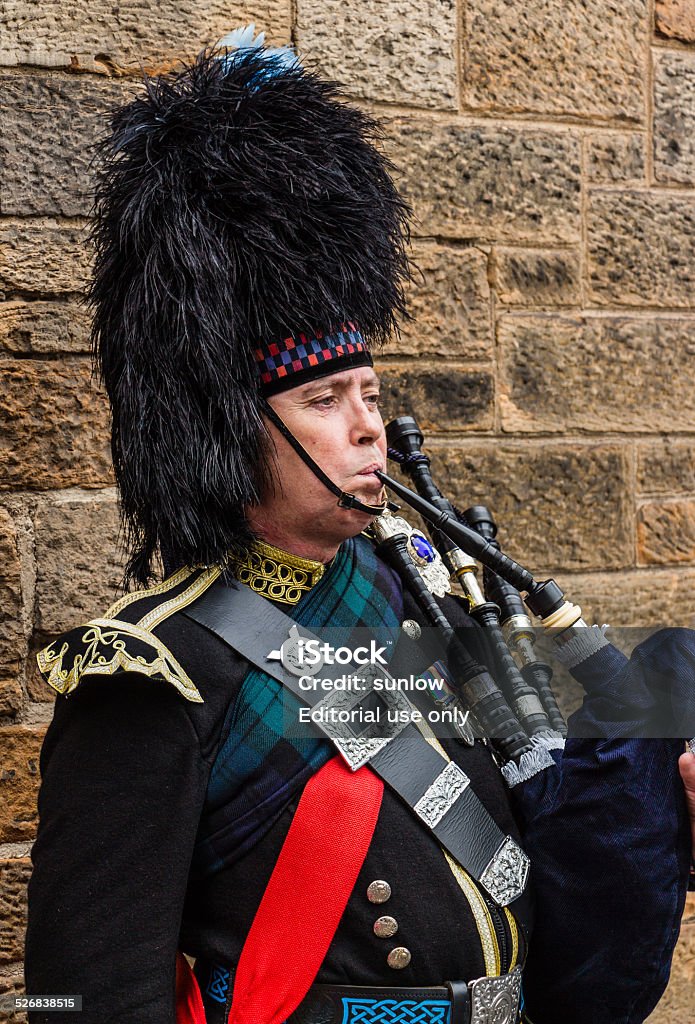 Portrait of a military dressed bagpiper playing the bagpipe Edinburgh, Scotland - September 14, 2014: Portrait of a military dressed bagpiper playing the bagpipe for the tourists roaming the Royal Mile. Army Stock Photo