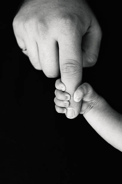 istock Newborn Gripping Dad's Finger 526839064