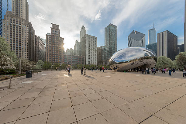 chicago millennium park in Downtown Chicago, IL, USA- April 21, 2016: Downtown Chicago.  Incidental people on the millennium park, Business buildings on the background. Cloud gate on the right side. millennium park chicago stock pictures, royalty-free photos & images