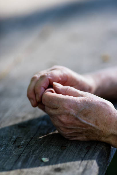 istock wrinkled hands of an old woman on a table 526845456