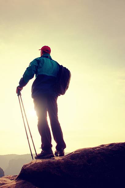 istock Hiker in windcheater, baseball cap and with trekking poles 526846410