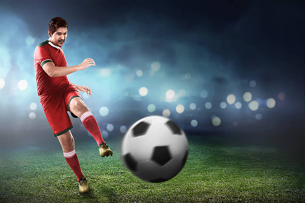 istock Asian football player kick ball 526846674