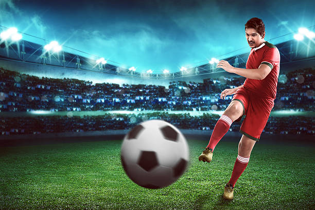 istock Asian football player kick ball 526846856
