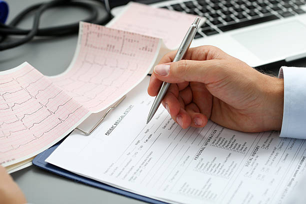 istock Male doctor hands with cardiogram chart on clipboard pad 526847098