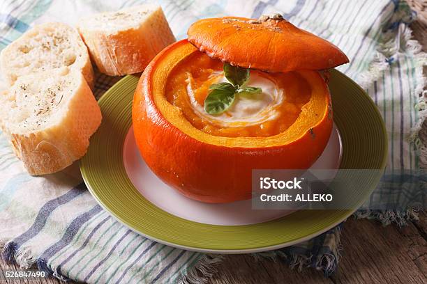 Puree Soup With Sour Cream And Basil In A Pumpkin Stock Photo - Download Image Now - Autumn, Backgrounds, Basil
