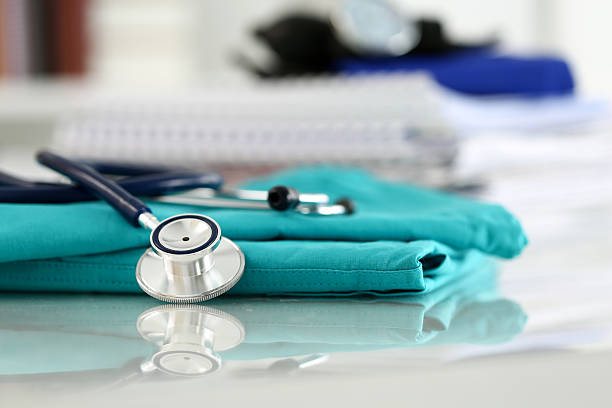 istock Medical stethoscope head lying on green doctor uniform 526848144