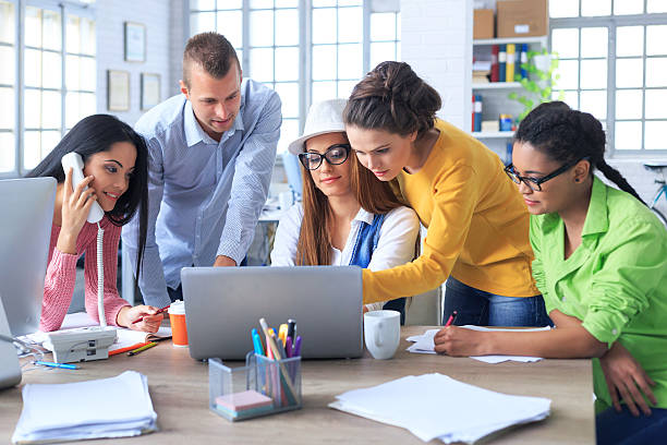 istock Group of young designers discussing new project at workplace 526849422