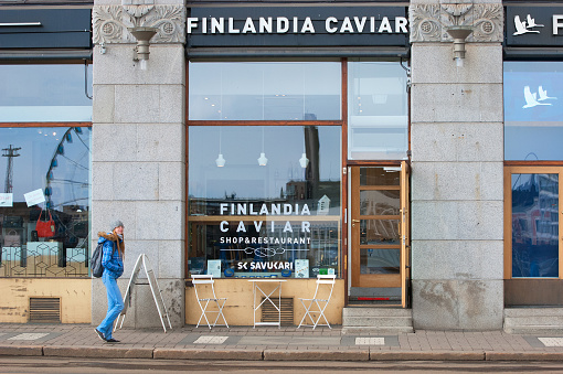 Helsinki, Finland - April 23, 2016: Girl walks near Finlandia Caviar Shop and Restaurant in the center of Helsinki not far from The Market Square