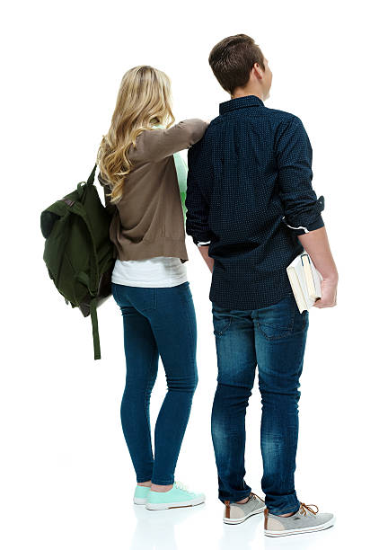 istock Rear view of two students holding books & standing 526854389