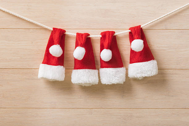 istock Santa hats on wooden background 526854423