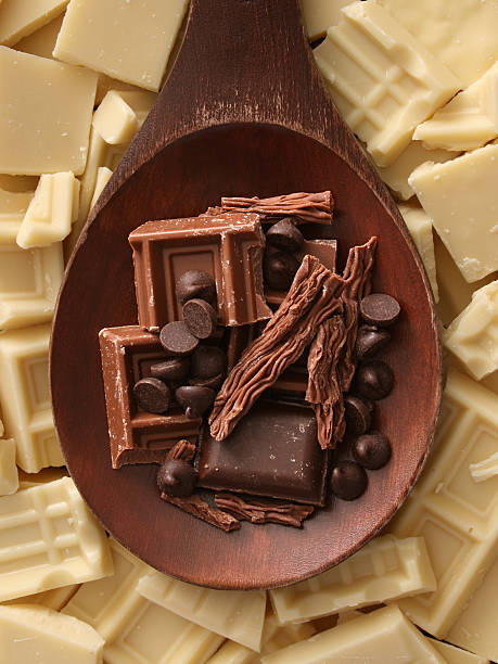 Dark and white chocolate Top view of wooden spoon with dark milk chocolate over it and white chocolate beneath it chocolate white chocolate chocolate chip white stock pictures, royalty-free photos & images
