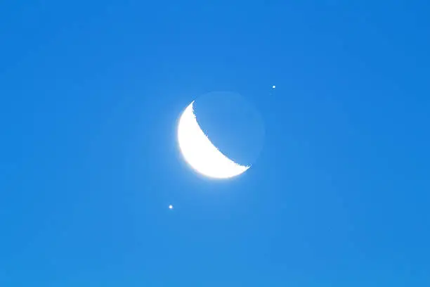 Moon conjunction with Venus (lower left) and Jupiter with its satellites (upper right).  Moon and planets taken by me with my apochromatic telescope and modified astronomy camera - stacked many exposures in professional astronomy software to reduce noise and to enhance details.