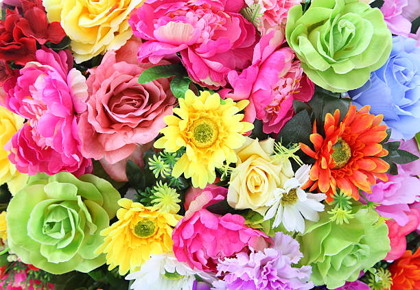 Background of bright colorful artificial flowers. Close up.