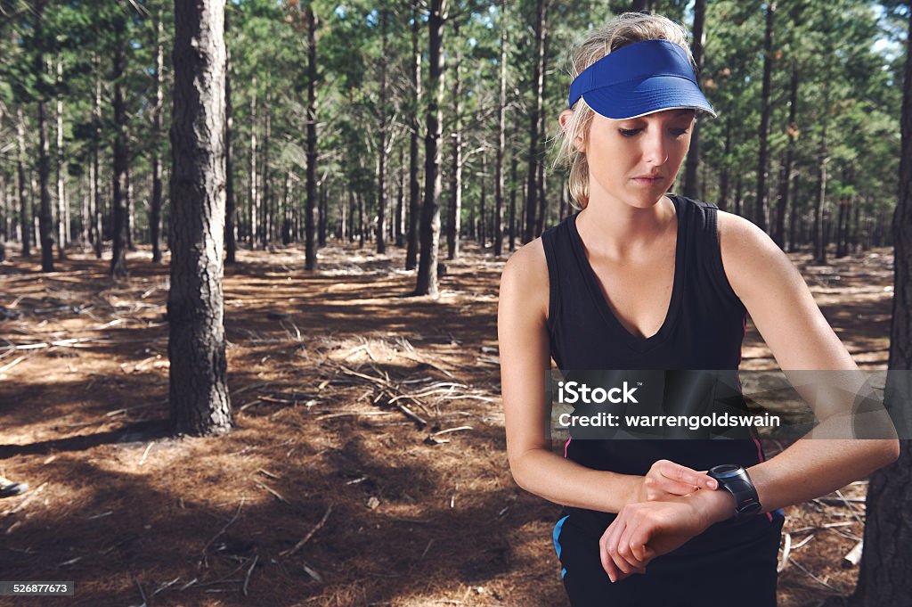 stopwatch trail runner Woman runner checking pace on gps sports watch in forest Activity Stock Photo