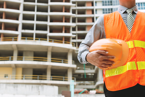 Cropped image of engineer with a hardhat at the construction site