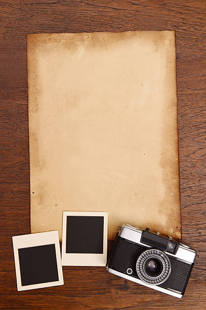 istock Old paper and vintage photo frame with camera 526880403