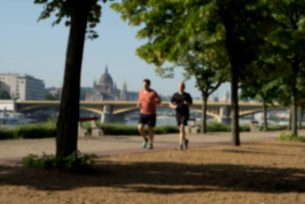 Running Young adult running in Margaret island in Danube river Budapest City. margitsziget stock pictures, royalty-free photos & images