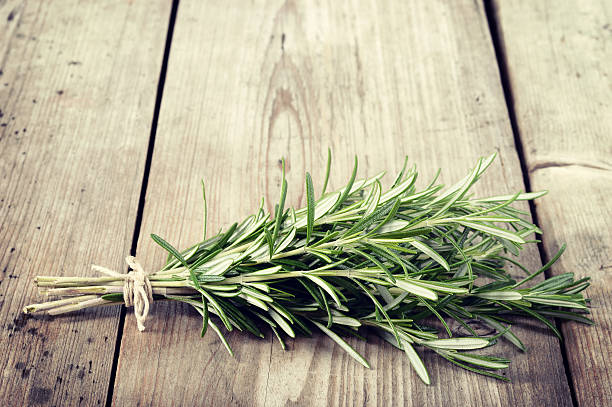 istock Fresh bunch of rosemary on wooden table. 526884089