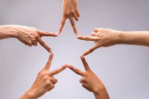 People forming star shape with their fingers