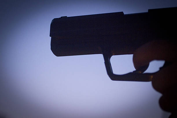 revólver pistola silhueta de mão com arma de fogo - handgun gun blue black imagens e fotografias de stock
