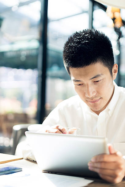 istock Asian businessman using tablet during break in cafe. 526897703