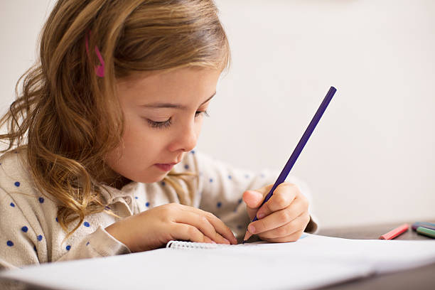 istock Innocent little girl doing homework 526897755