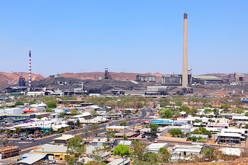 The Mount Isa Mine dominates the town of Mt Isa on a very hot summer day.  Elevated view from lookout.  Horizontal, copy space.