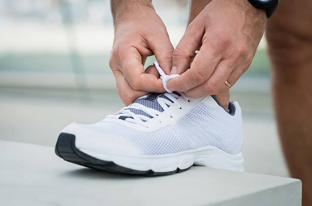 biegacz człowiek sznurowanie butów - shoe tying adult jogging zdjęcia i obrazy z banku zdjęć