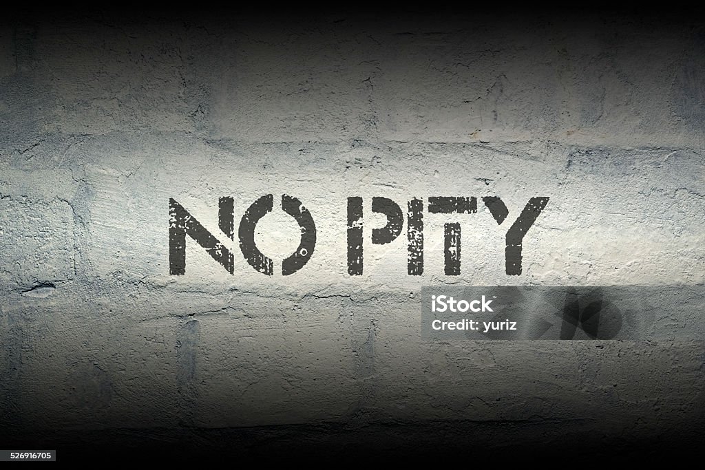 no pity no pity stencil print on the grunge white brick wall Brick Stock Photo