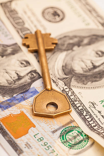 istock Closeup of key on hundred dollar bills 526917507
