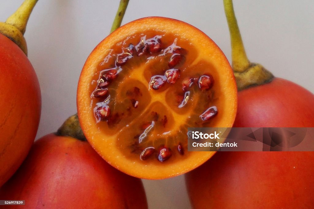 Tamarillo Fruits - Tree Tomatoes Whole and halved fresh Tamarillo fruits on white background. Close-up Stock Photo