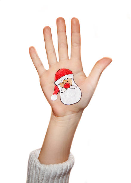 istock Kid's hands with painted Christmas symbol, Santa 526920759