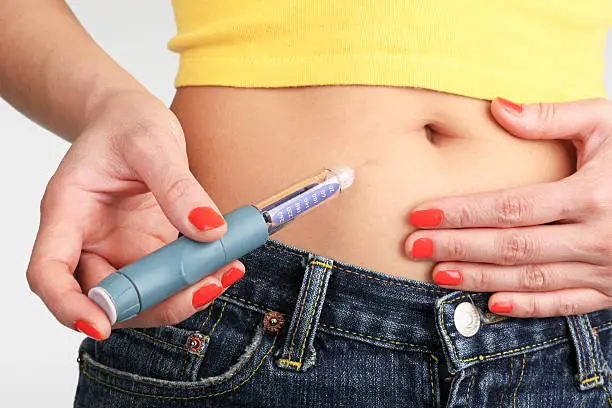 Young woman is injecting Insulin with a Insulin Pen, Freiburg, Germany