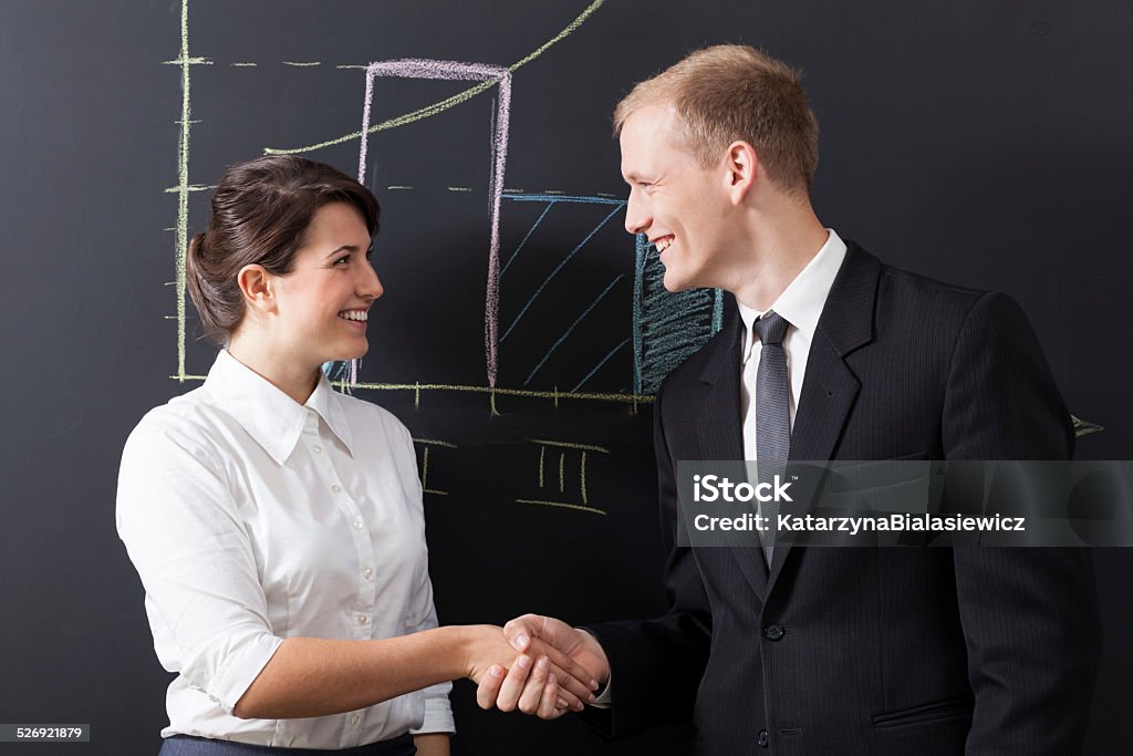 Shaking hands Portrait of businesswoman and businessman shaking hands Adult Stock Photo