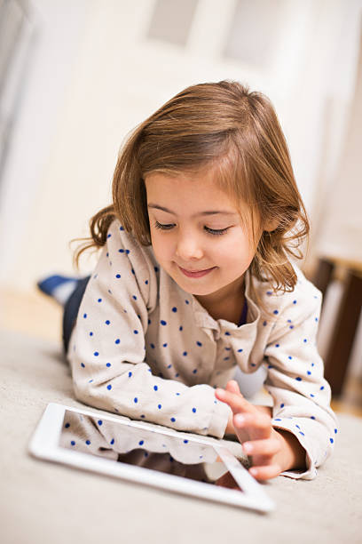 istock Cute little girl on floor using digital tablet 526927291