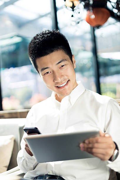 istock Asian businessman using tablet during break in cafe. 526927357