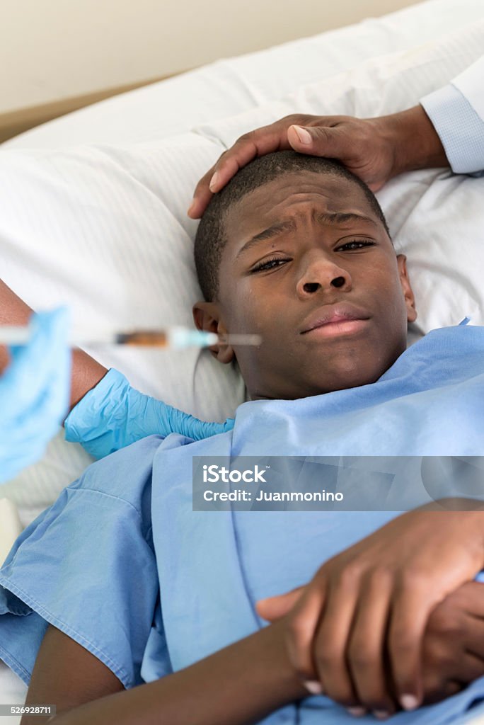 fear of needles scared teenage boy, the doctor is going to give him a shot 14-15 Years Stock Photo